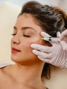 Practitioner giving a Botox injection near a woman's eye